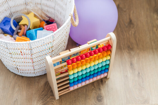 white basket with silicone baby toys abacus and balloon early learning concept