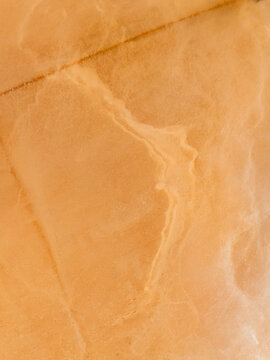 Aerial view of the textured salt pans with orange hues and natural mineral patterns in Marsala, Sicily, Italy.