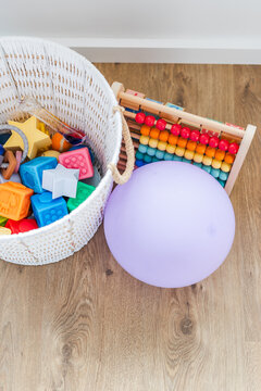white basket with silicone baby toys abacus and balloon early learning concept