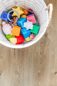 white basket with silicone baby toys abacus and balloon early learning concept