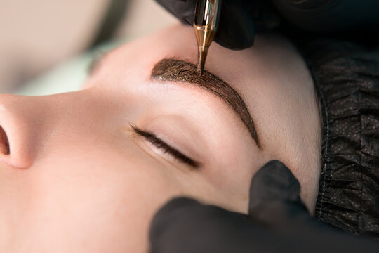 Permanent tattoo makeup procedure. Eyebrow tattoo make-up. Brow tattoo. Close up, selective focus