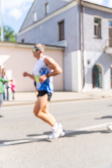 Obraz premium Blurry action shot of a male runner in sportswear