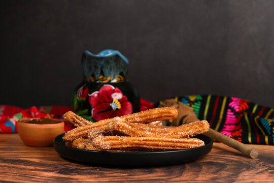 Traditional Mexican snack with churros, artisanal jar and wooden whisk (molinillo)