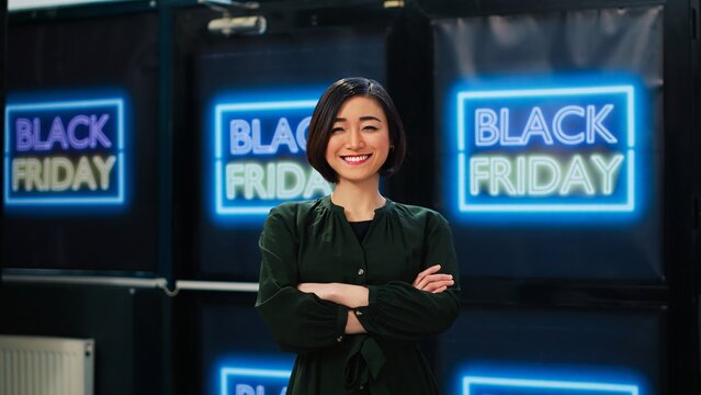 Asian woman shopping on black friday in clothing store, feeling happy about seasonal sales and discounted clearance items. Shopper visiting retail shop on big sales event, outlet boutique.