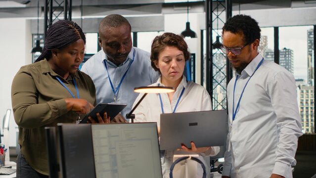 Portrait of smiling engineering team in office automating workflows using artificial intelligence tech. Happy coworkers refining deep learning computational models for faster processing, camera B