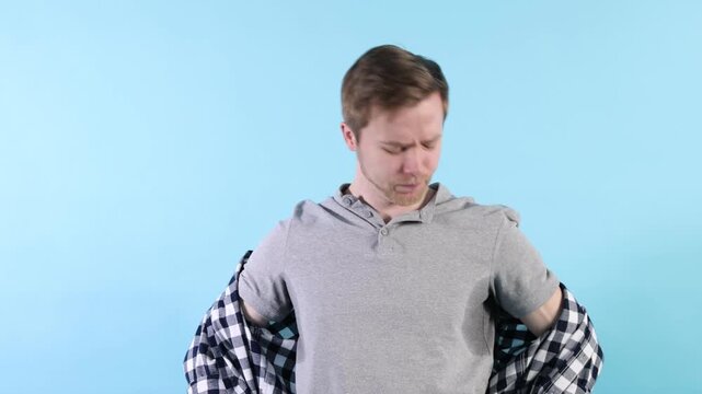 Man with sweaty armpits on light blue background