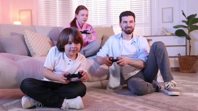 Emotional family with controllers playing video game together at home, camera moving backwards