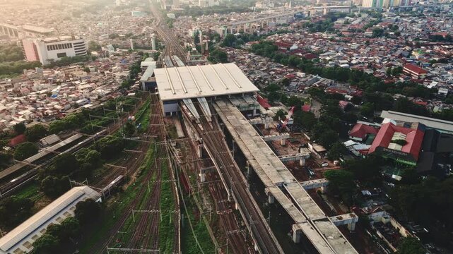 Aerial View Of Urban Train Station With Multiple Platforms And Tracks.