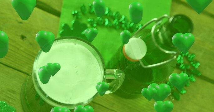 Showing foamy mug on wood table by orange-seal bottle, green garland, shamrock confetti, 3D hearts