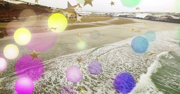 Showing shoreline and surf rolling onto wet sand on beach, bokeh circles and gold stars overlaying
