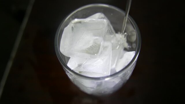 POV: slowly pouring a glass of soda. Serving a glass of guarana soda. Close-up of a soda glass. A glass full of ice. Guarana soda with ice cubes. Iced soda. A soft drink. A fizzy drink. A pop