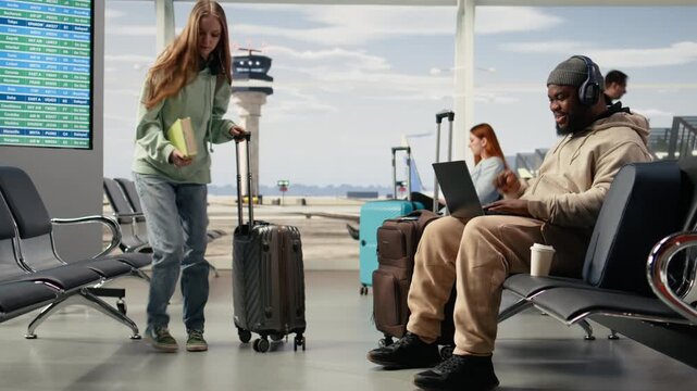 Digital nomad participating in online video call in airport terminal lounge, virtual meeting with client while waiting for flight departure. Telecommuting and work anywhere nomadic lifestyle.