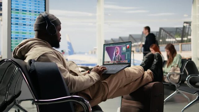 Digital nomad photo editor working on laptop in airport lounge, editing photography materials and retouching for advertising agency project while waiting for departure. Freedom to work anywhere.