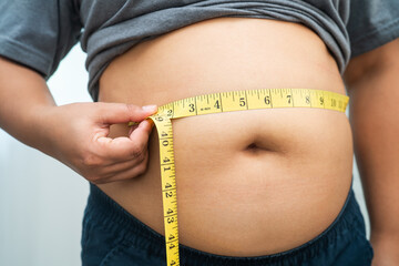 Asian woman with fat belly big size overweight and obesity with measure tape.