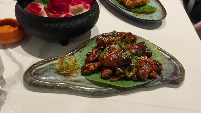 Crispy chilly baby corn served with rose and schezwan momo