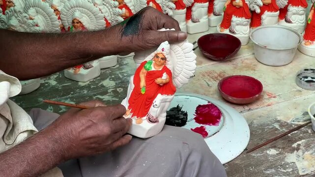 Artisan making small clay gods in Kumartuli, Kolkata; a glimpse into the traditional idol-making industry and cultural heritage of India.