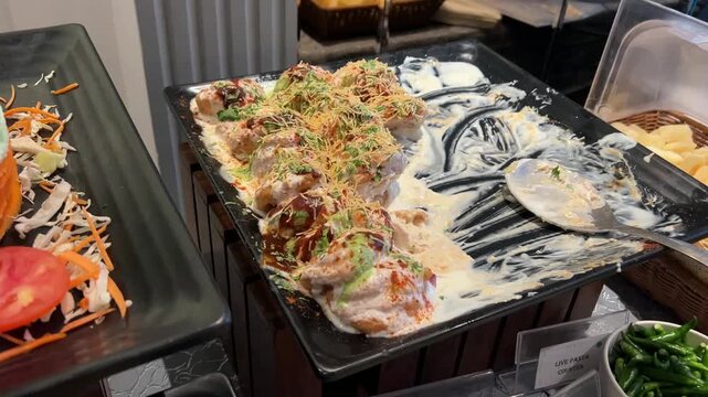 Soft lentil dumplings (Dahi Vada) soaked in creamy whipped yogurt and drizzled with sweet tamarind and spicy green chutneys at a wedding.