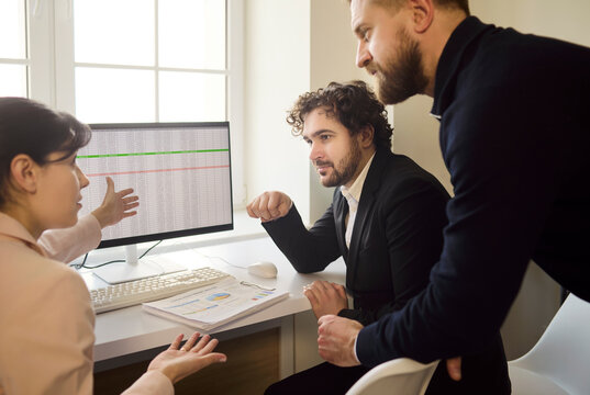 Team meeting discussion with colleagues conducting analysis. They review data spreadsheets and charts on a monitor while the manager guides decisions. Concept teamwork, leadership and strategy.