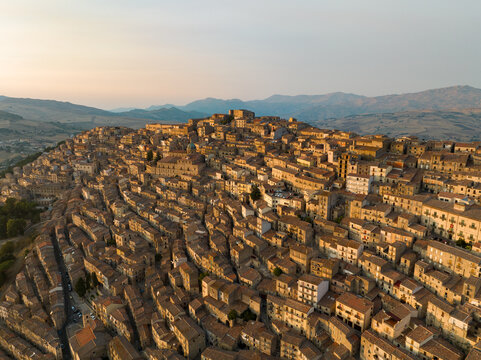 Aerial view of the historic hilltop town of Gangi with its tightly packed stone houses on a steep slope during golden hour in Gangi, Sicily, Italy.