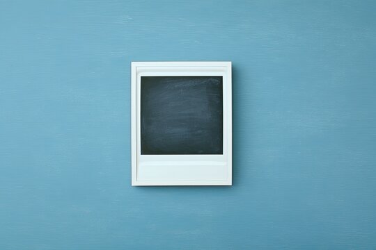 Blank instant photo frame on a textured blue surface