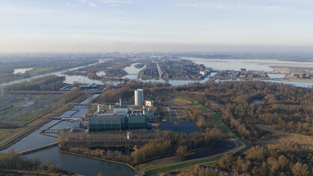 Aerial view of the Vattenfall Elektriciteitscentrale Diemen power plant with industrial buildings and cooling towers near waterways and forests in Diemen, Noord-Holland, Netherlands.