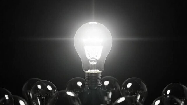 A bright light bulb shines above other dark light bulbs, representing a new idea