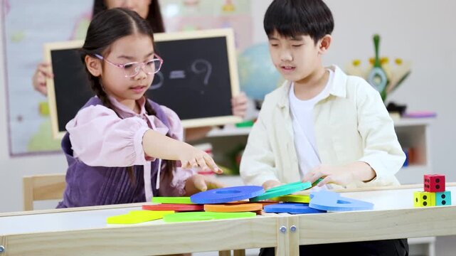Asian Primary Students Learning Mathematics With Colorful Number Shapes in Classroom