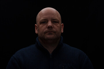 Fototapeta premium Portrait of a serious looking man in dark moody lighting