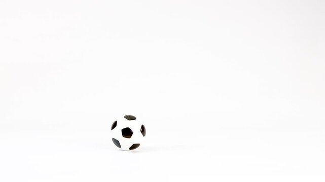 Miniature Soccer Balls Bouncing and Rolling on a Plain White Background