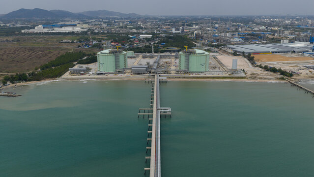 Aerial view of the PTTLNG Nong Fab LMPT2 terminal featuring large storage tanks and a long industrial pier extending into the sea Tambon Map Ta Phut, Chang Wat Rayong, Thailand.