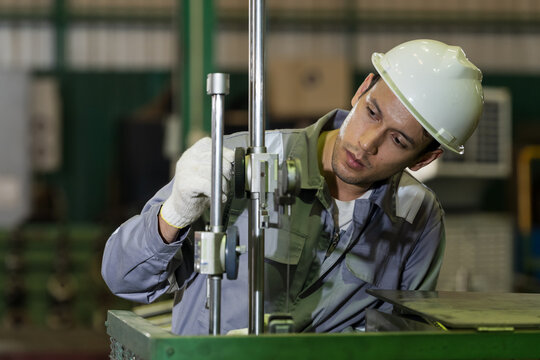 Adult male technician inspects precision measuring fixture at close range, adjusting gauge alignment for quality control, maintenance accuracy, and reliable manufacturing setup during workshop work.