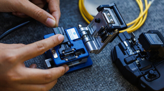 Fiberoptic Fusion Splicing Technician , Internet cable connection, fiber optic fusion splicing machine. Concept of fiber optic connection by skilled technicians.