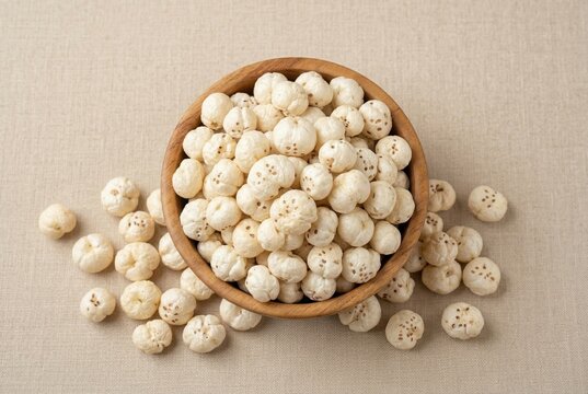 Healthy roasted phool makhana or fox nuts in a wooden bowl on a textured background