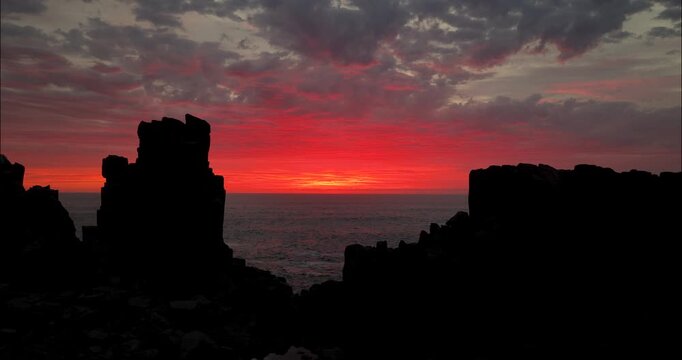 Cinematic Drone Push In Past Rock Formations Under Red Dawn Sky Kiama
