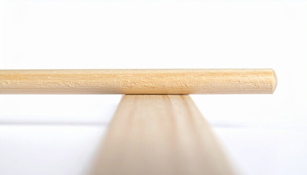 Close-up of a wooden dowel rod resting on a flat wooden plank surface