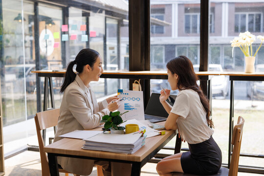 Business women discussing financial data in modern office