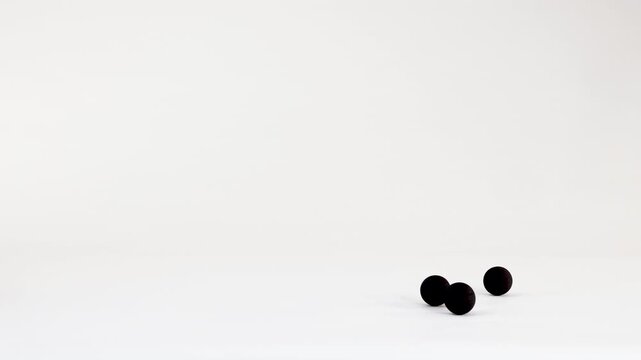 Minimalist Animation of Black Spheres Bouncing Across a White Background