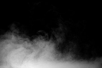 Fototapeta premium White fog and smoke rising from the bottom on a black background, creating an atmospheric mist texture ideal for visual effects, cinematic scenes, overlays, graphic design.
