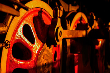 Steam locomotive driving wheels in warm sunset light with industrial detail