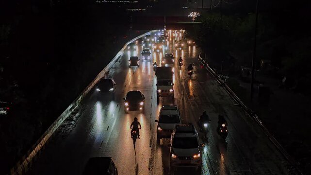 A Shot of Night Traffic on Wet Road in Delhi India with Headlights
