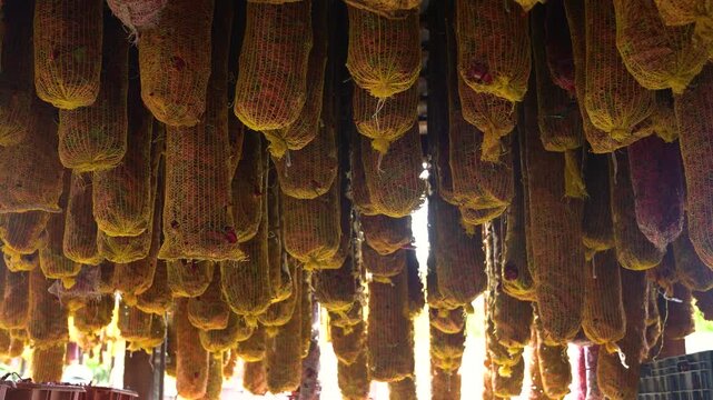 Drying red peppers hanging in mesh bags for traditional spice preparation