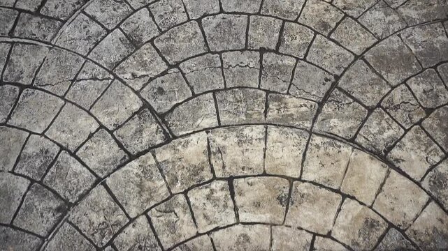 Footsteps walking on a curved patterned stone floor with classic texture