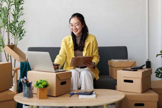 Young Asian woman managing online small business at home