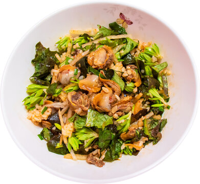 Mixed Cockle Bibimbap in white bowl isolated on transparent background, PNG : Korean food "Cockle Bibimbap", boiled rice mixed with cockles, vegetables (lettuce, sedum), sliced Asian pear and sauce.