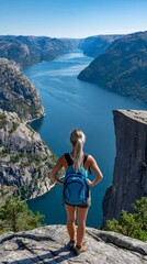 Naklejka premium Woman hiking looking at lysefjord from preikestolen cliff