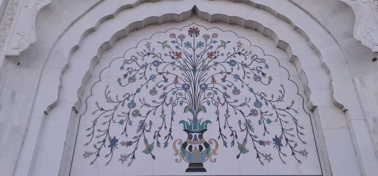 Beautiful traditional marble inlay work with floral patterns and a decorative vase design on a temple wall
