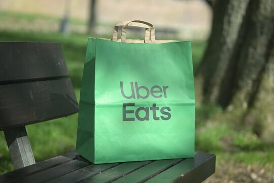 Neu-Ulm, Germany - April, 16, 2026: Uber eats food delivery Paper bag standing outdoors. Horizontal image with soft focus.
