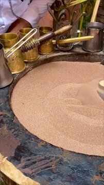 Making oriental coffee on the sand at a market in Marrakech