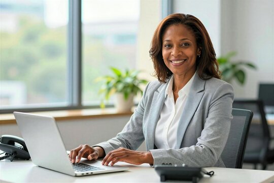 Middle Aged Woman With African Descent Seated In Office Environment Shoulder Length Curly Hair Styled Naturally Showcasing Warm Brown Tones Complexion Fair Adorned