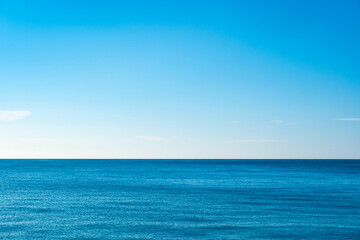 Fototapeta premium A bright, clear blue sky meets a glowing white horizon, suggesting a serene, open, and with sunlight of beautiful cloudy sky. landscape or abstract background 